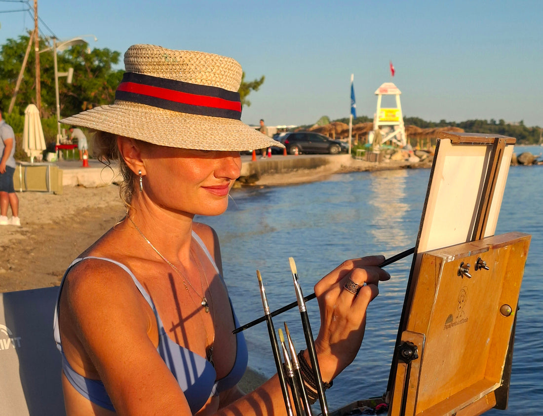 PAINTING ON A BEACH AGAINST THE SUN